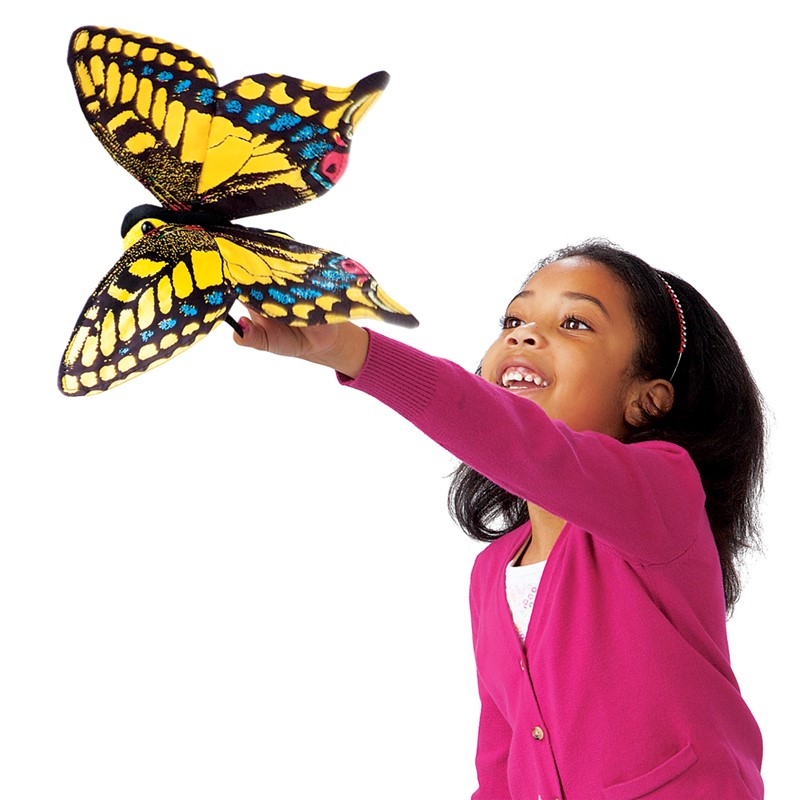 Girl holding up a Folkmanis swallowtail butterfly hand puppet with yellow-and-black wings