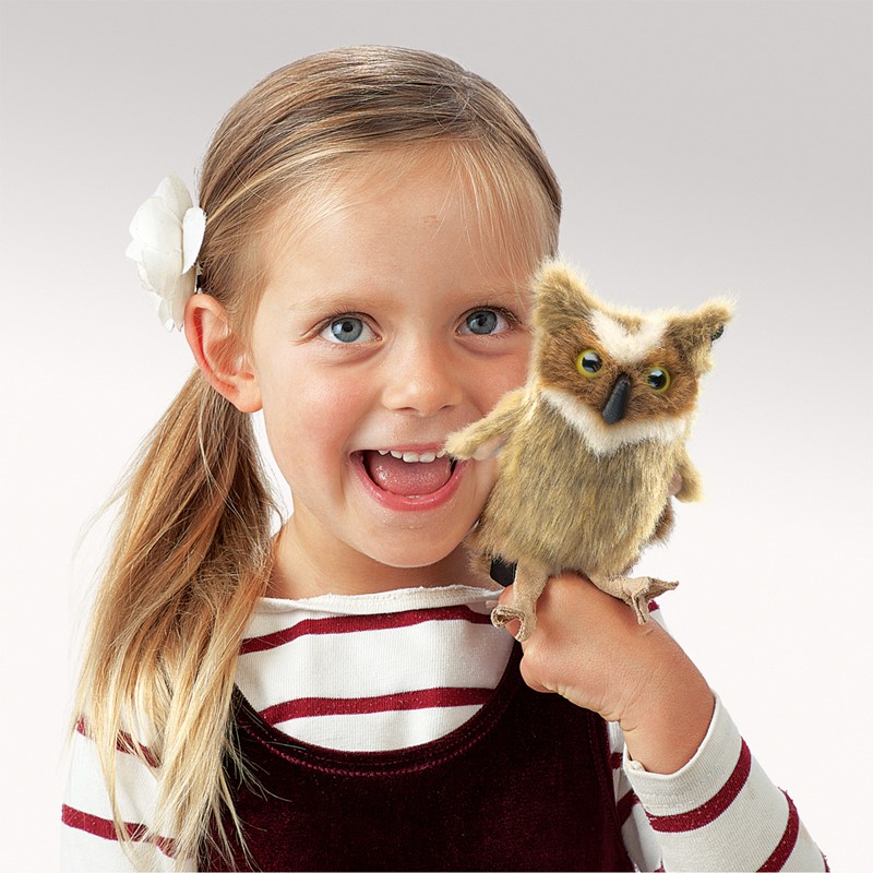 Girl holding a Folkmanis mini great horned owl finger puppet with brown fur and yellow eyes on her finger