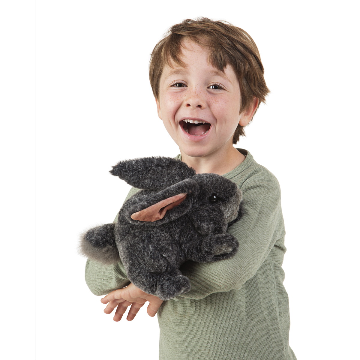 Lachender Junge hält graue Folkmanis Handpuppe Kaninchen mit rosafarbenen Ohren und flauschigem Fell in beiden Händen