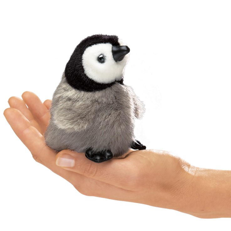 Folkmanis Mini-Fingerpuppe Baby Kaiserpinguin mit grauem Plüschbauch und schwarzem Kopf, auf einer Handfläche sitzend