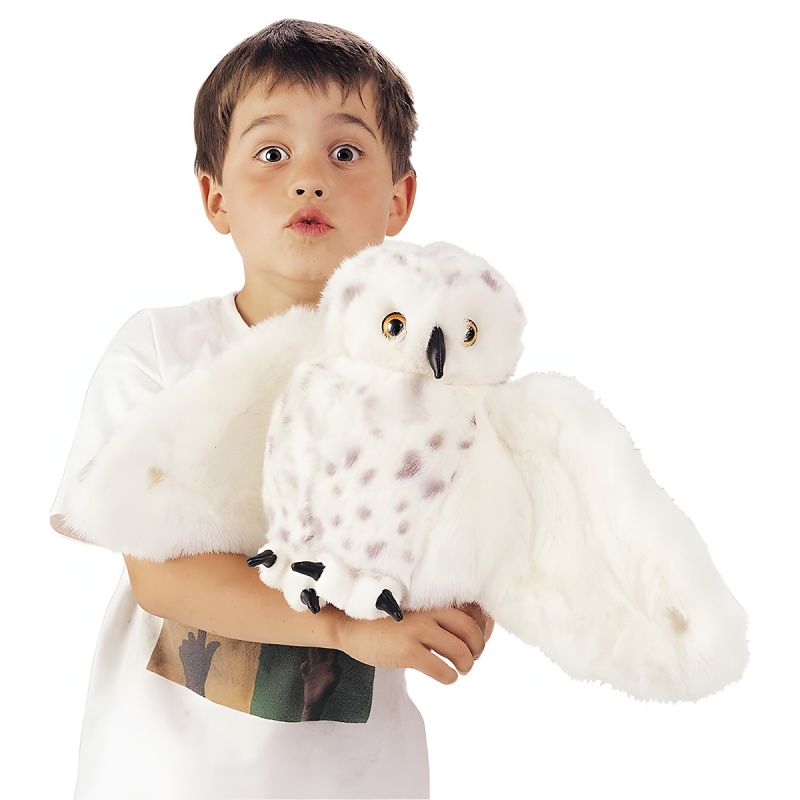 Junge hält die Folkmanis-Handpuppe Schneeeule mit ausgebreiteten Flügeln